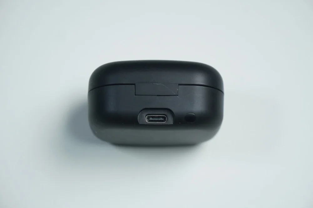 TRUEFREE Clip C10のケース画像。背面部分の充電端子とボタンが映っている。