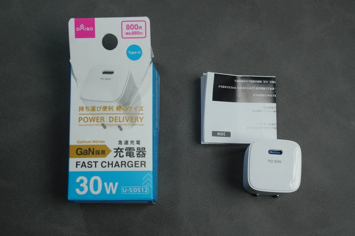 ダイソーの30W GaN充電器のパッケージ・取扱説明書・本体を並べた同梱物一式の写真