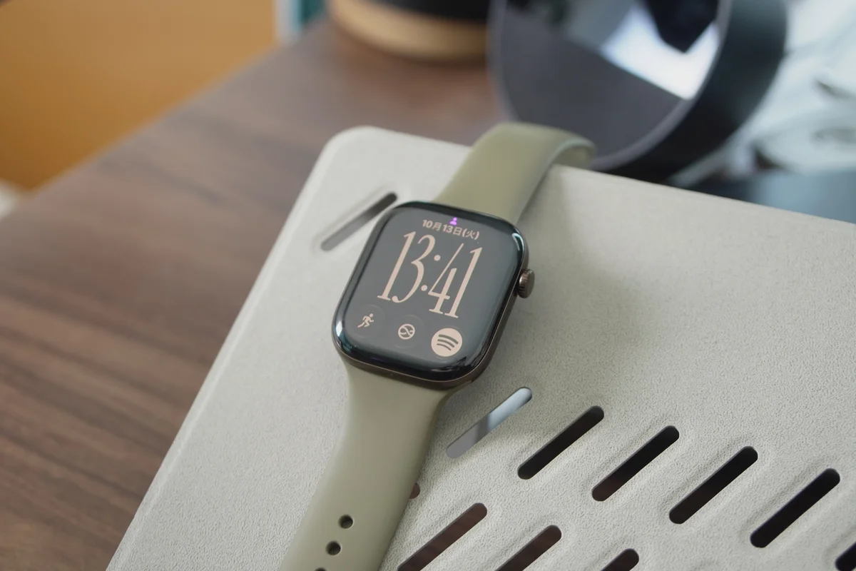 オリーブのスポーツバンドを付けたApple Watchの画面を点灯させた状態の写真